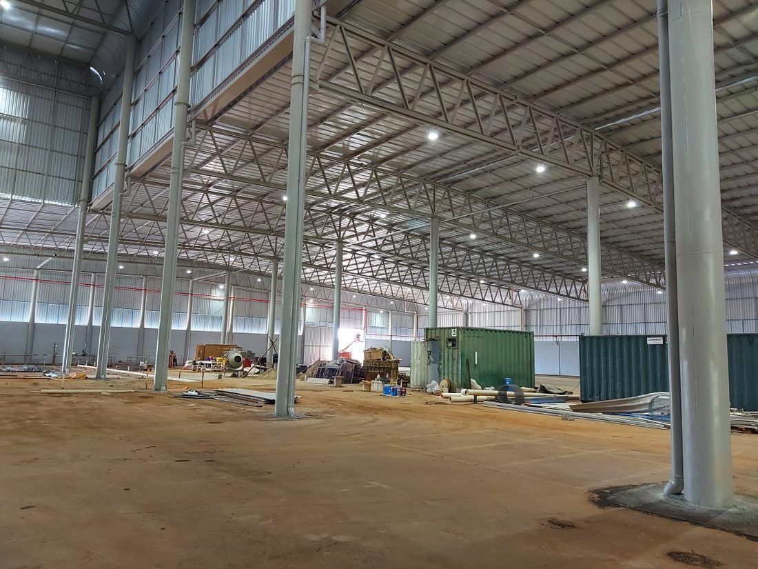 Interior do galpão da CofcoAgri em Alfenas durante o acabamento, com a estrutura metálica aparente