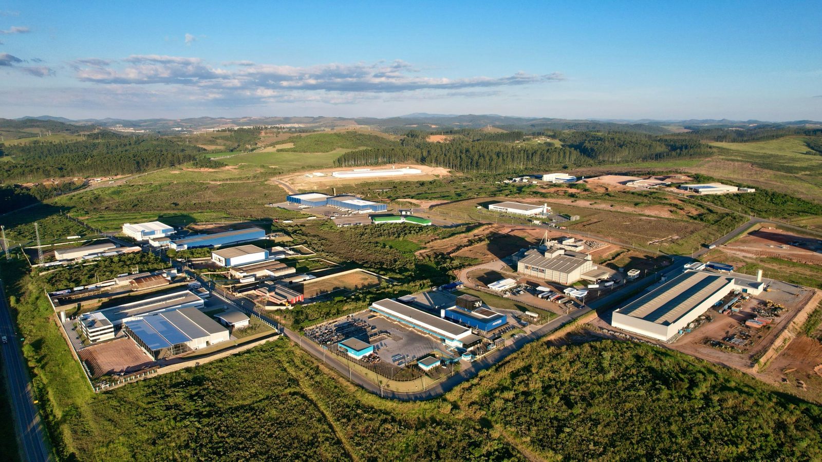 Vista aérea do Distrito Industrial de Poços de Caldas, com galpões implantados e áreas em terraplanagem